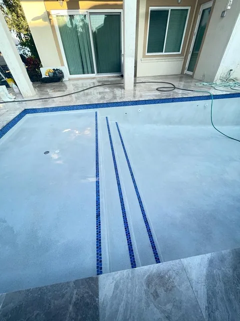 New light pool finish with blue tile lane lines and a glass tile waterline