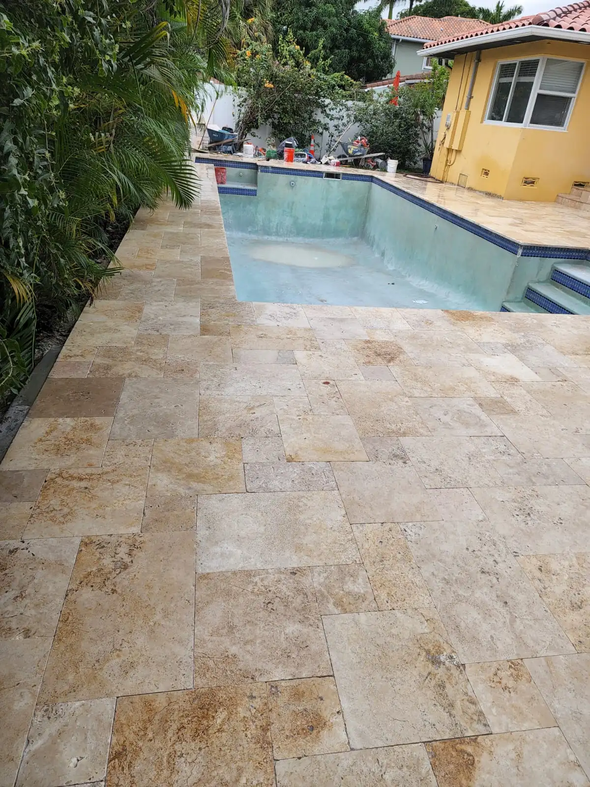 Close view of tumbled travertine pavers meeting the pool edge and steps